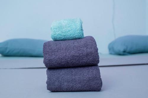 a stack of towels on a table with two beds at Los Angeles to Conakry *KIPE* in Conakry