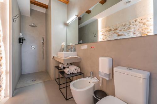 a bathroom with a toilet and a sink and a mirror at Hotel Mas De Cebrian in Puertomingalvo