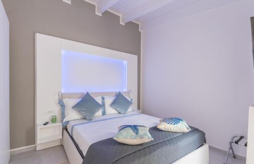 a bedroom with a bed with two pillows on it at Capo Norax chambre de luxe avec jacuzzi à 250m de la mer in Pula