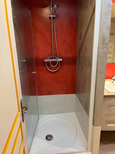 une douche avec une porte vitrée dans une salle de bain dans l'établissement Grand logement 3 pièces, à Gries