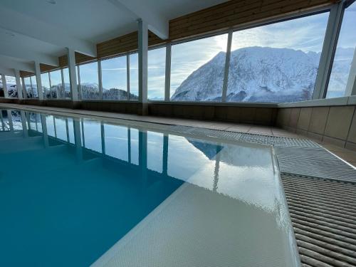 a swimming pool with a view of a mountain at White Rose apartment in Kulmhof in Tauplitz