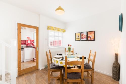 a dining room with a table and chairs and a kitchen at Arden Holiday Lettings in Stratford-upon-Avon
