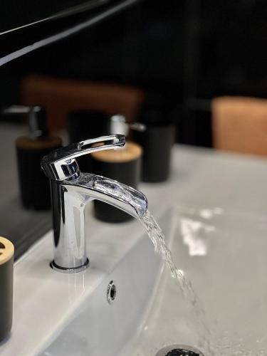 un fregadero con agua saliendo de un grifo en Luxury house Como, en Como