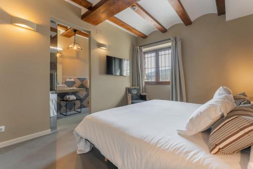 a bedroom with a large white bed and a window at Hotel Mas De Cebrian in Puertomingalvo