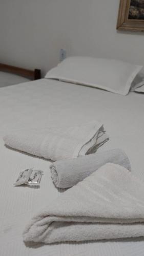 a bed with white towels on top of it at POUSADA RIO PERUYPE in Nova Viçosa