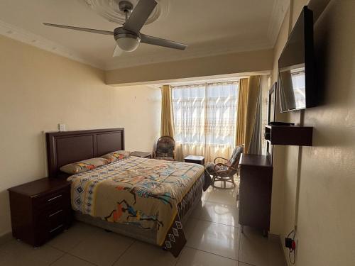 Un dormitorio con una cama y un ventilador de techo. en Tenbury Beach Apartment 208, en Durban