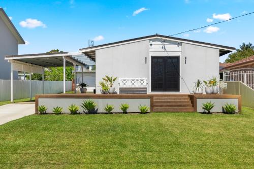 a white house with a lawn in front of it at OnPoint at Vincentia in Vincentia