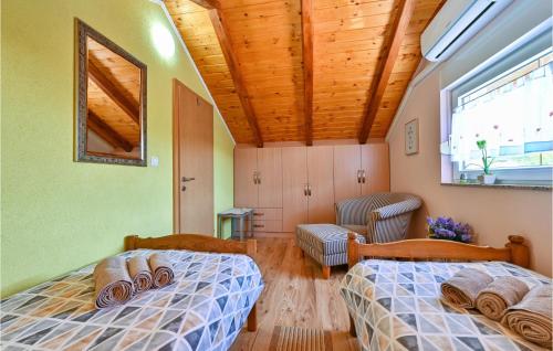 a bedroom with two beds and a couch and a window at Amazing Home In Susobreg With Wifi in Jertovec