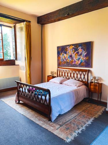 une chambre avec un lit et un tableau au mur dans l'établissement Le domaine de Kerousy, à Plouguiel