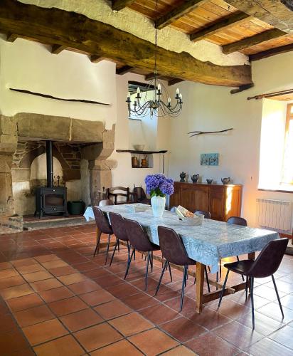une grande salle à manger avec une table et une cheminée dans l'établissement Le domaine de Kerousy, à Plouguiel