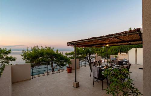 a patio with a table and chairs under a pergola at Beautiful Home In Prigradica in Prigradica