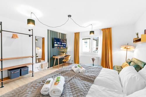 a bedroom with a large bed with towels on it at Lemon3 - SAP Arena & Maimarkt - Smart-TV - Self-Checkin - Free Parking in Mannheim