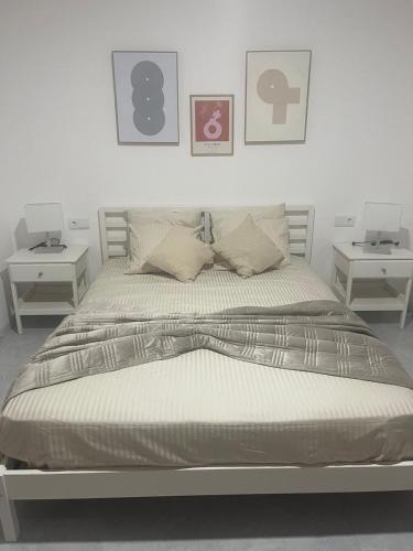 a bedroom with a bed with two end tables at Felicidade apartamento Palmarejo Grande in Praia