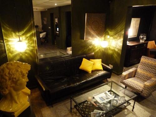 a living room with a black leather couch and a mirror at Etche Ona in Pyla-sur-Mer