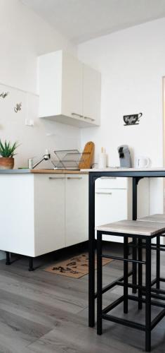 une cuisine avec des armoires blanches et une table et des chaises dans l'établissement La Shekinah-Chambre dorée, au Creusot