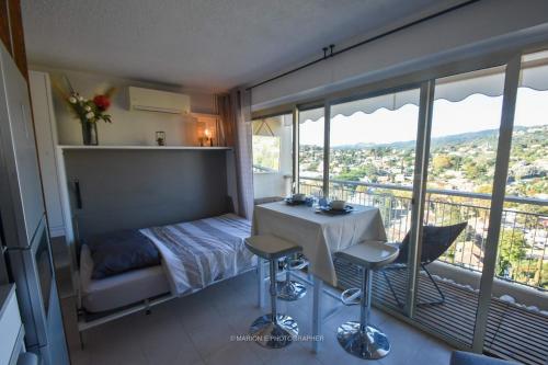 - une chambre avec un lit, une table et quelques fenêtres dans l'établissement Studio 2 étoiles - Sur le port - Cannes Marina, à Mandelieu-la-Napoule