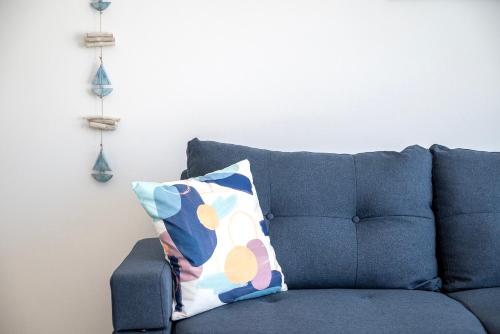 a blue couch with a pillow in a living room at XENOS VILLA 6 With a private pool near the sea in Tigaki