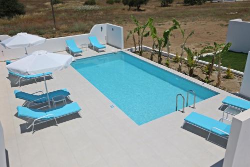 a swimming pool with chairs and umbrellas at XENOS VILLA 6 With a private pool near the sea in Tigaki
