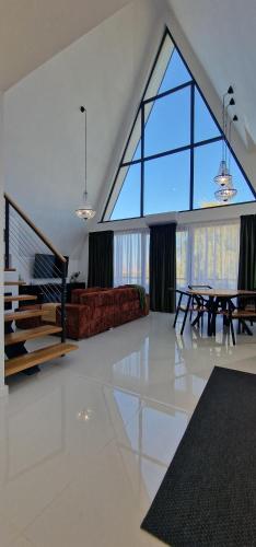 a living room with a large window and a table at VillaGrey Tunari in Tunari