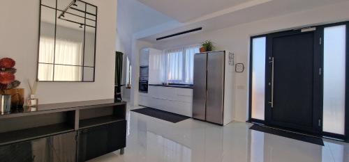 a kitchen with a stainless steel refrigerator and black cabinets at VillaGrey Tunari in Tunari