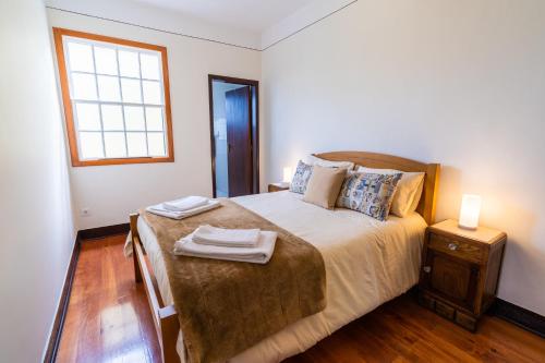 a bedroom with a bed with two towels on it at Sleep Among the Bananas! Rustic Cottage with Trails at Your Doorstep in Ponta do Sol