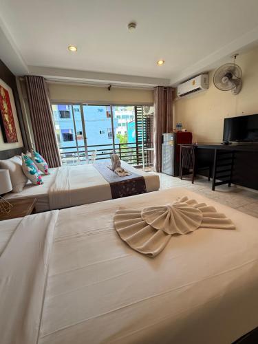 a hotel room with two beds and a desk at Thai Classic House in Patong Beach