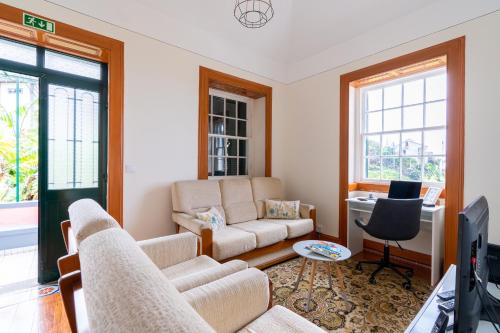 un soggiorno con un divano e una TV di Sleep Among the Bananas! Rustic Cottage with Trails at Your Doorstep a Ponta do Sol