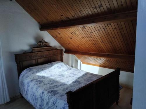 a bedroom with a bed with a wooden ceiling at Villa lumineuse proche plage in Wissant