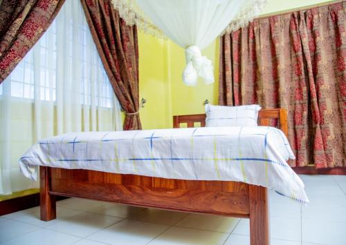 a bedroom with a wooden bed with a window at Afr Hostel in Arusha