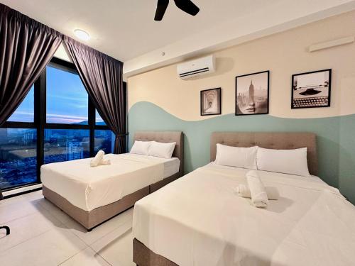 two beds in a room with a window at 2 bed room 5 queen bed luxury sea view apartment in Jelutong