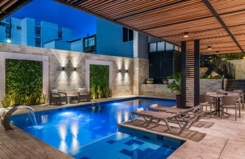 a swimming pool with a table and chairs next to a building at Hotel Elite in Barrancabermeja