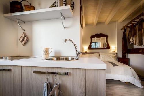 a kitchen with a sink and a bed in the background at Le Casette Apartments - byMyHomeinComo in Blevio