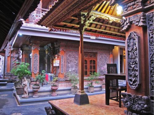 una habitación con un templo con una mesa y un piano en Warini Bungalows, en Ubud