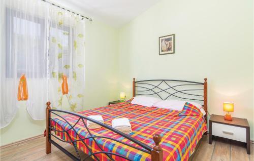a bedroom with a bed with a colorful comforter at Awesome Home In Meloni With Sauna in Karojba
