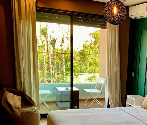 Studio lumineux avec piscine/Gare casa oasis في الدار البيضاء: غرفة نوم مع سرير وإطلالة على الشرفة