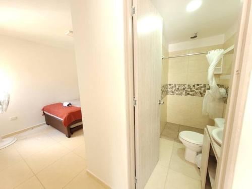 a bathroom with a toilet and a bed in it at F111- Apartamento cerca al Club Campestre con piscina in La Tebaida