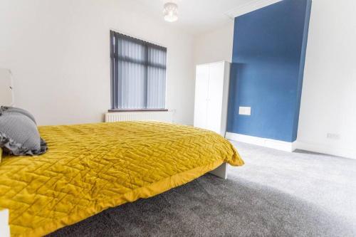 a bedroom with a yellow blanket on a bed at Spacious 4 Bedroom House in Stoke on Trent in Stoke on Trent