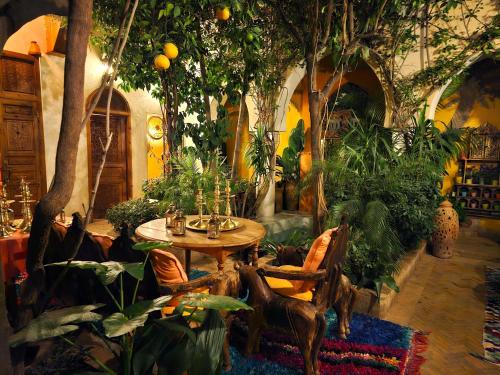 a room with a table and lots of plants at Riad Jnane d'Ô in Marrakech