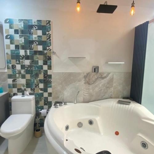 a bathroom with a white tub and a toilet at Casa - Habitaciones en Roldanillo Valle in Roldanillo