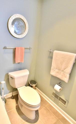 a bathroom with a toilet and a mirror and towels at Large 3 Bedroom, Tremont House, minutes from everything!! in The Angle
