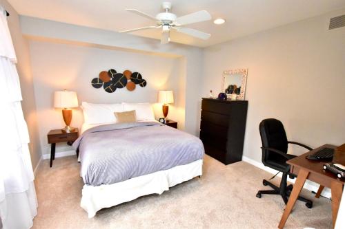 a bedroom with a bed with a ceiling fan and a desk at Large 3 Bedroom, Tremont House, minutes from everything!! in The Angle