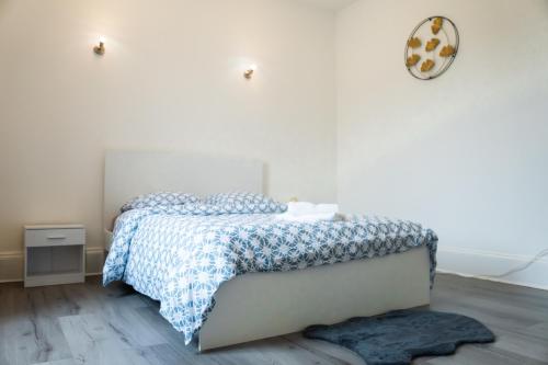 une chambre avec un lit et une horloge au mur dans l'établissement La Shekinah-Chambre dorée, au Creusot