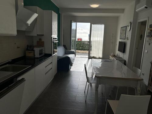 a kitchen with a table and a couch in a room at Casa SERGE vista mare con ampio terrazzo privato in Bergeggi