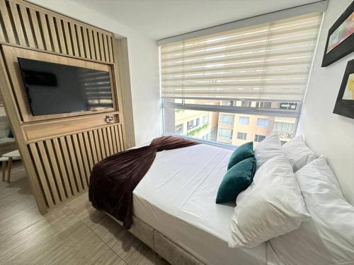 Un dormitorio con una cama y una ventana grande en M510- Apartaestudio en Av19 Norte con parqueadero, en Armenia