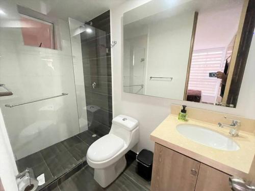 Un baño con inodoro, lavabo y ducha. en M510- Apartaestudio en Av19 Norte con parqueadero, en Armenia