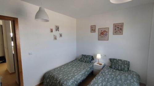 a bedroom with two beds and a lamp in it at Sunnydays in Roldán