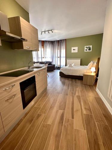a kitchen with wooden floors and a bed in a room at HH Hermoso Housing ALESSANDRIA in Alessandria