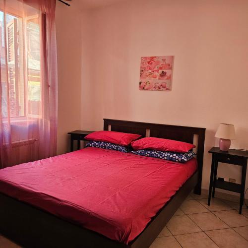 a bedroom with a bed with red sheets and a window at Casa Alessio, luminosa, centrale, ad un passo dal mare in Varazze