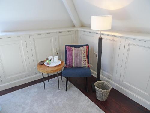 a room with a table and a chair and a lamp at Guest house La Maison Chantecler in Brussels