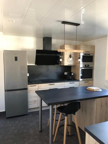 Il comprend une cuisine équipée d'une table noire et d'un réfrigérateur. dans l'établissement Gîte 'Au cœur de Maîche', 1 à 6 personnes, à Maîche